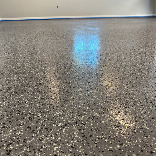 A close up of a gray and white epoxy floor in a garage.