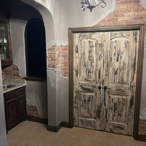A room with a brick wall and a wooden door