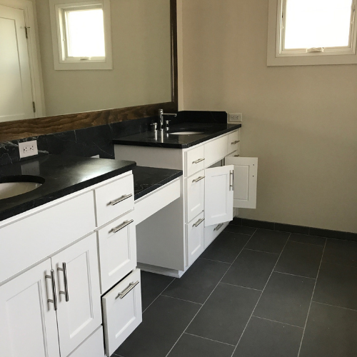 A bathroom with two sinks and a mirror