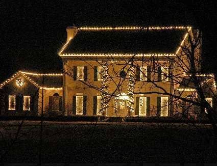 a large house is lit up with christmas lights at night
