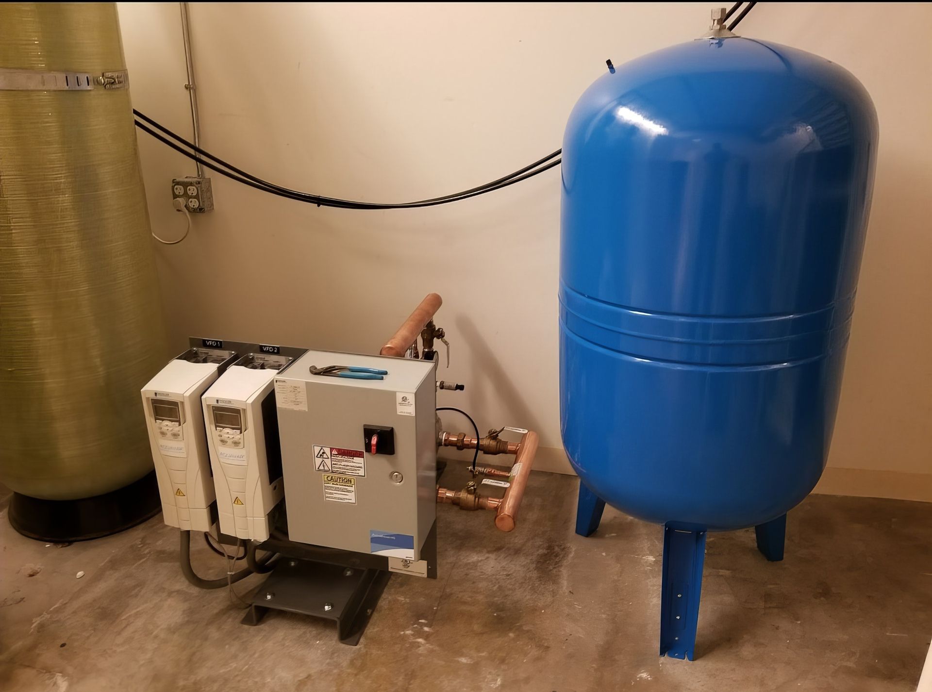 Industrial boiler and water system with blue pressure tank, control box, and pipes in a utility room