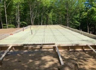 un sol en béton est en cours de construction au milieu d une forêt.