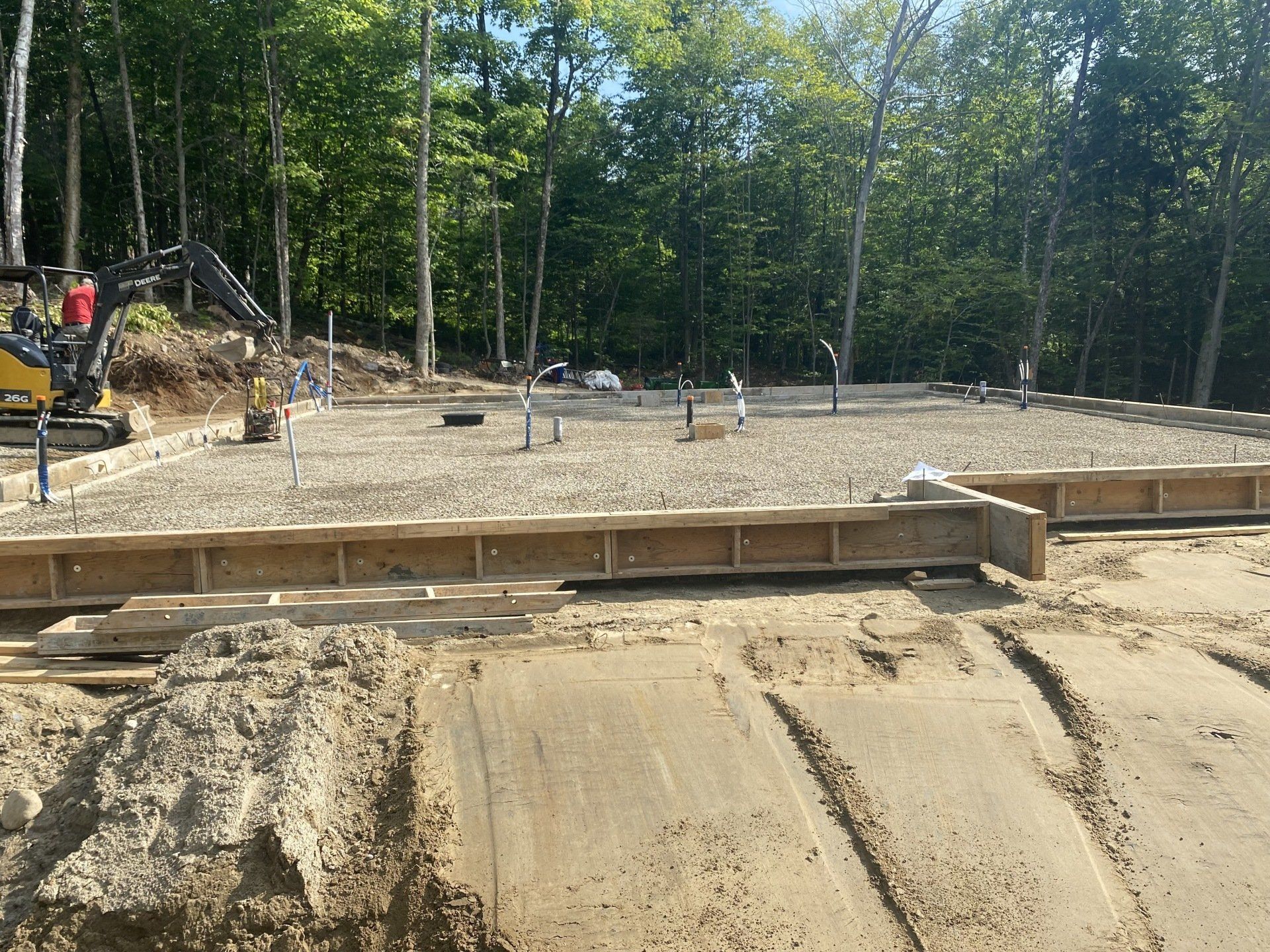 un chantier de construction avec beaucoup de terre et d arbres en arrière-plan.