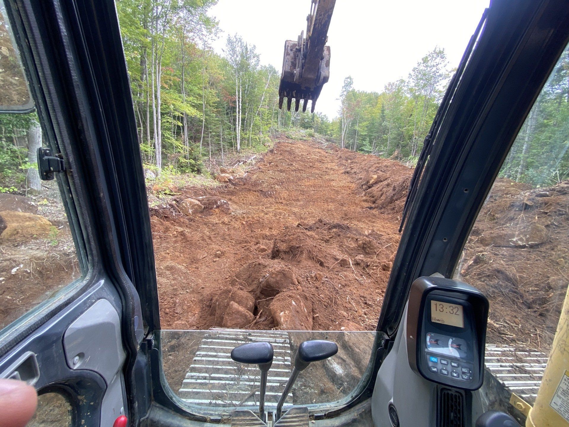 une personne conduit un bulldozer sur un chemin de terre.