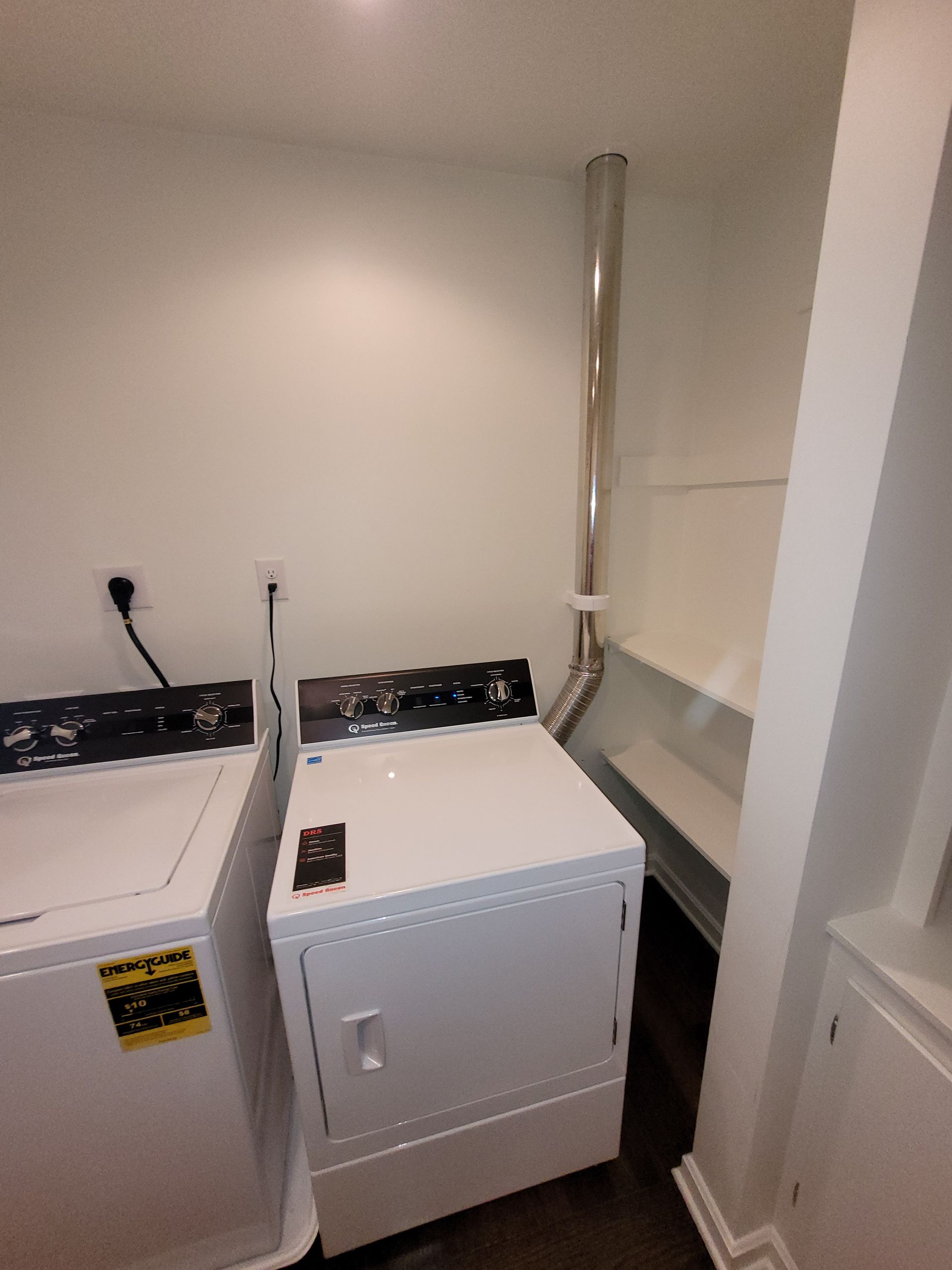 Laundry machines, white appliances in a room.