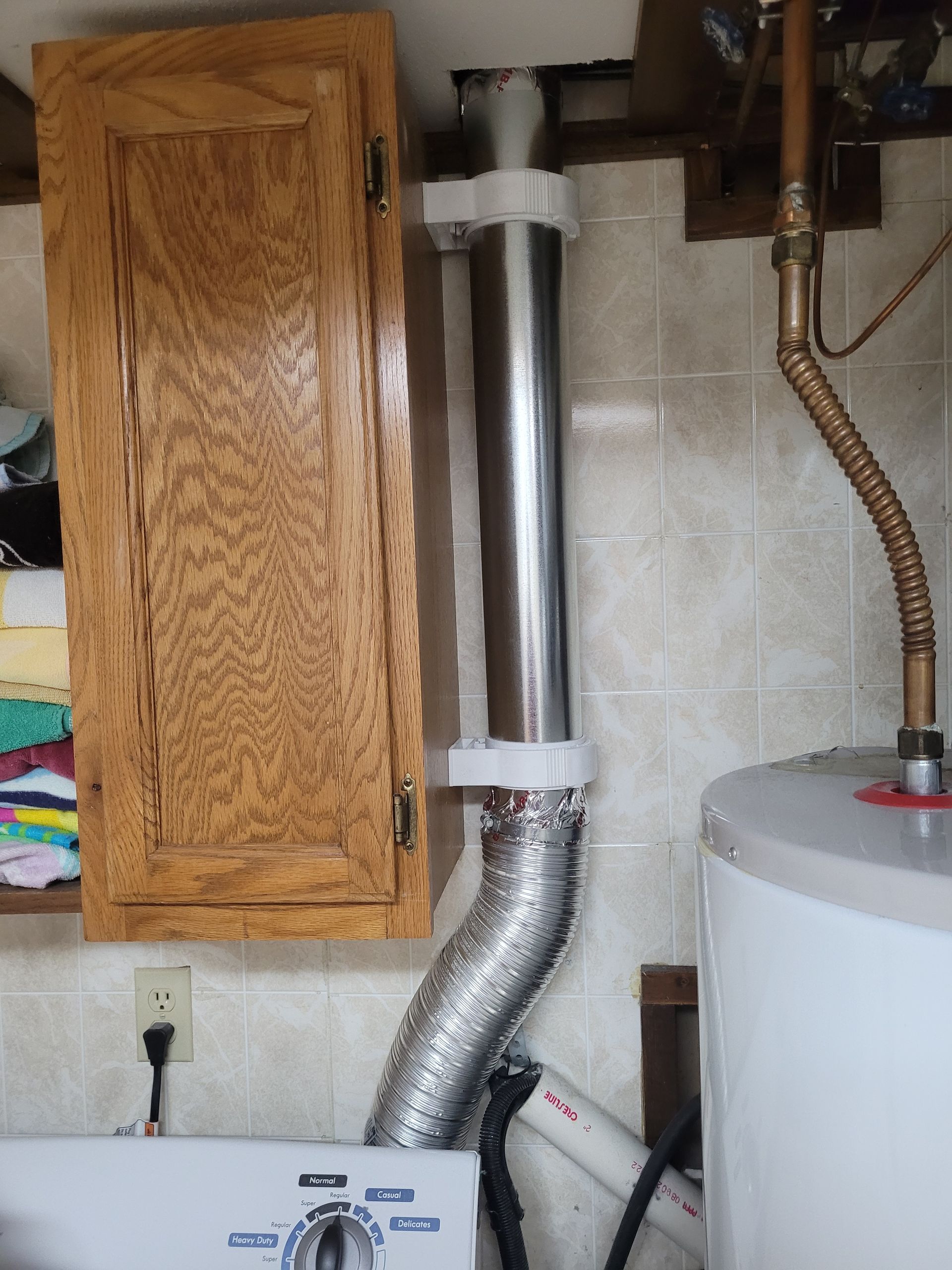 Laundry room with dryer vent connected to an angled exhaust pipe.