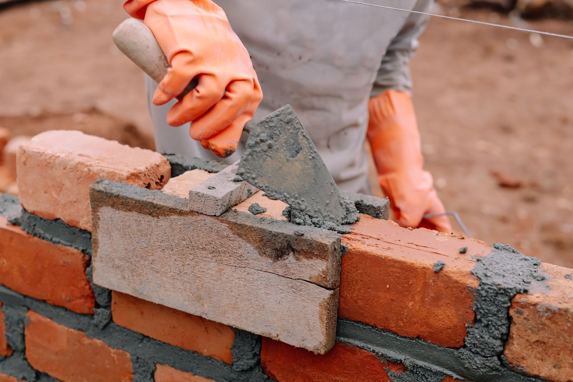 Mason is laying bricks with a trowel and mortar. Mason is laying bricks with a trowel and mortar.