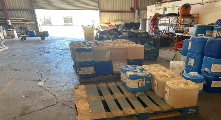 A warehouse filled with lots of barrels and pallets.