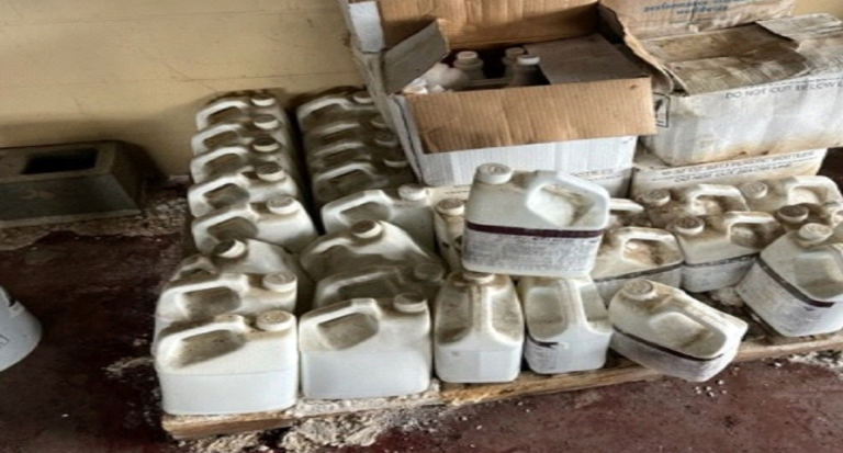 A bunch of plastic containers are stacked on top of each other on a wooden pallet.