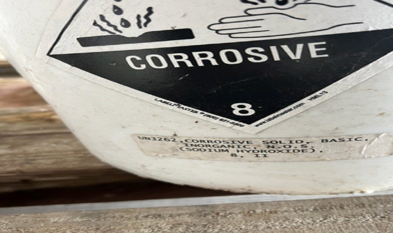 A white container with a label that says corrosive on it