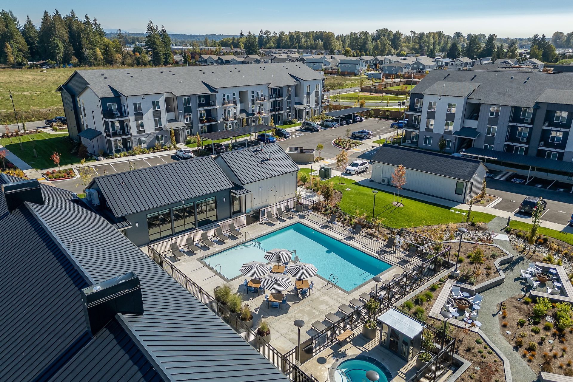 Aerial view of a modern apartment complex with a central swimming pool and landscaped courtyard