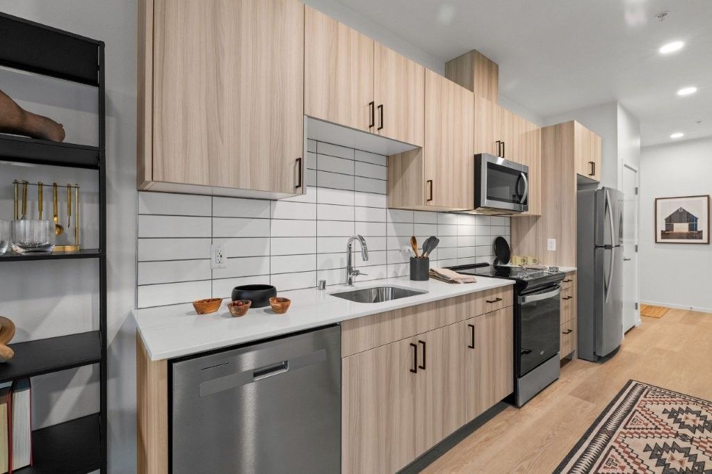 A kitchen with stainless steel appliances and wooden cabinets.