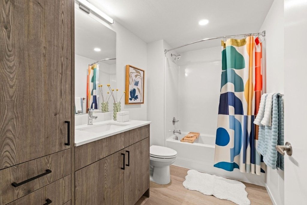 A bathroom with a sink , toilet , bathtub and shower curtain.