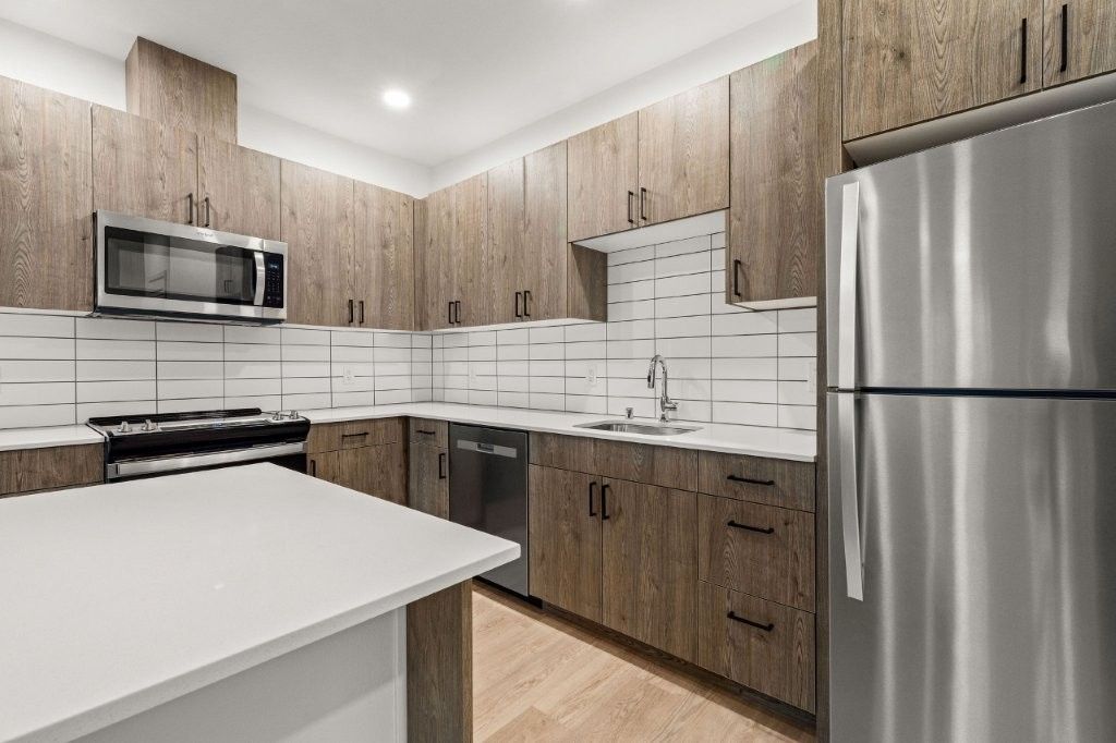 A kitchen with stainless steel appliances and wooden cabinets.