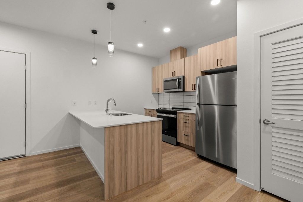 A kitchen with stainless steel appliances and wooden cabinets.