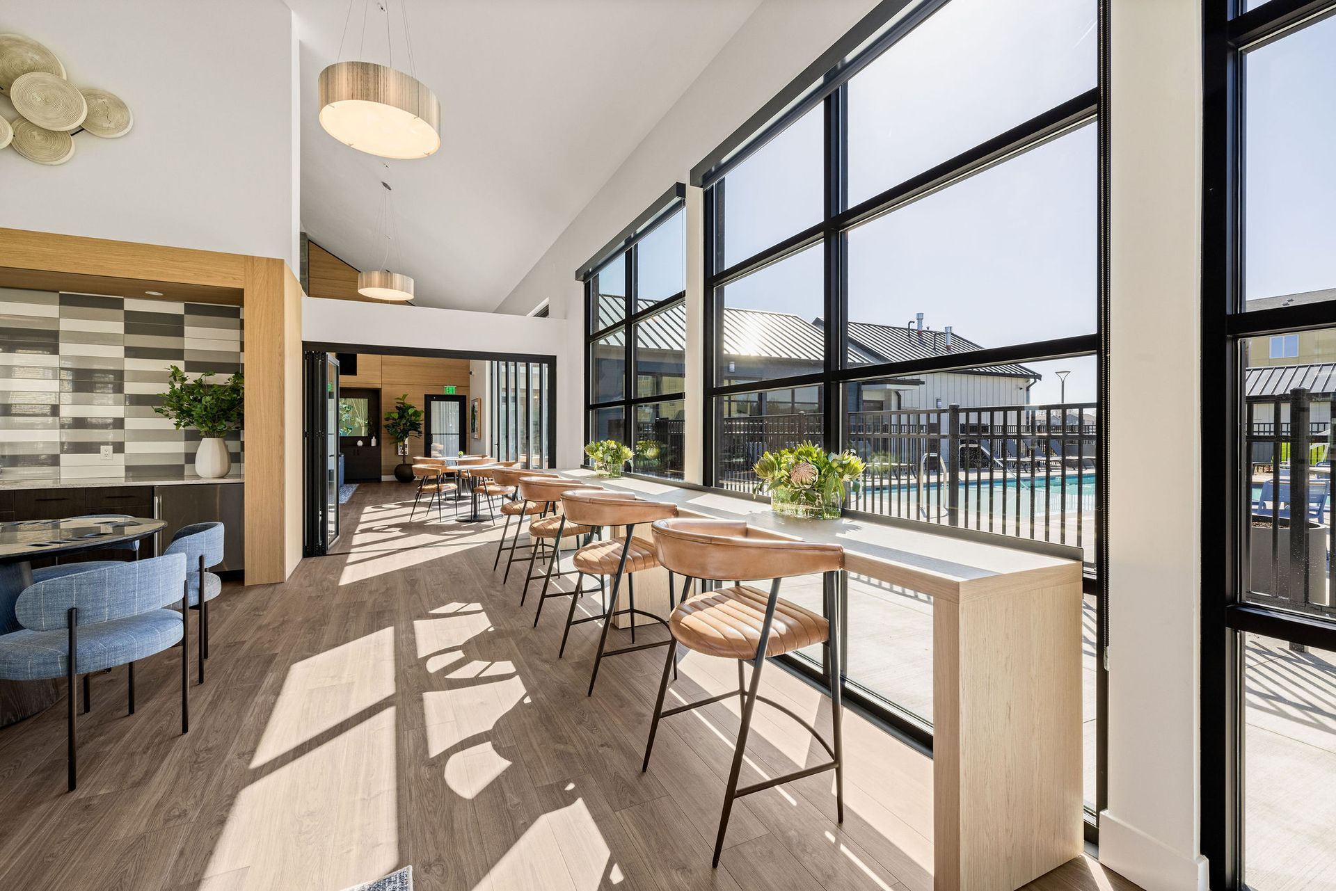 A large room with a lot of windows and tables and chairs.