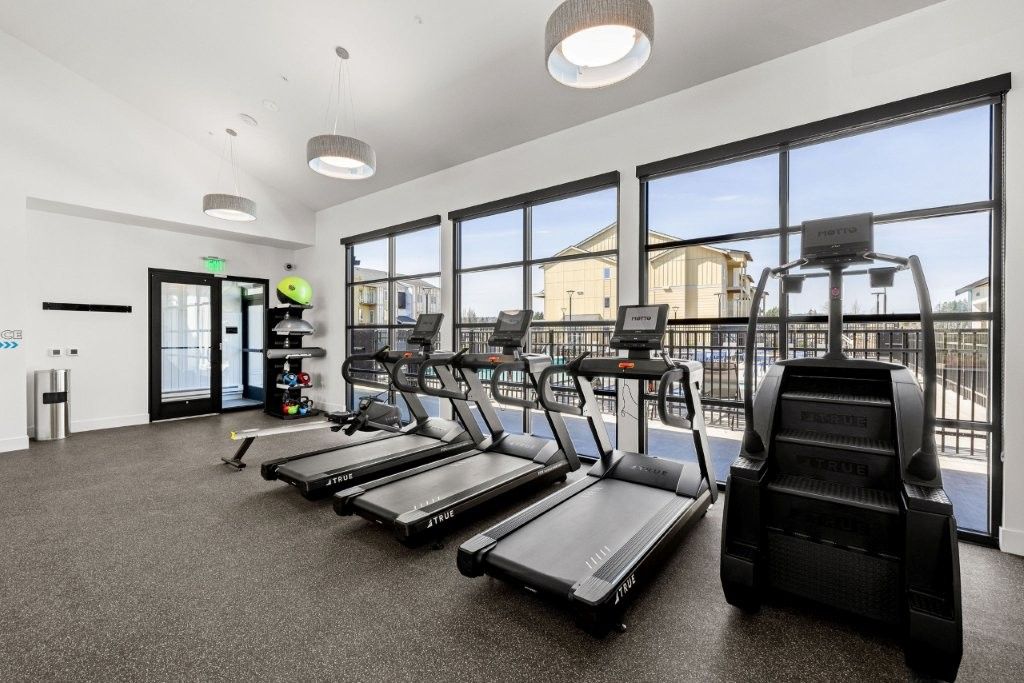 A gym with a lot of treadmills and stairs.