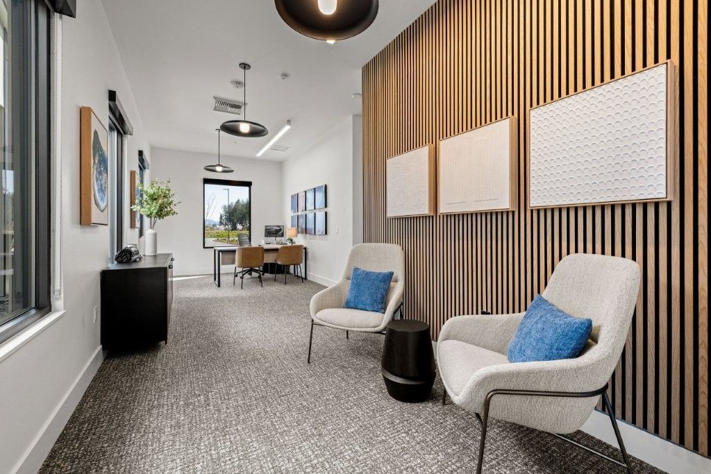A hallway with two chairs and a table in a living room.