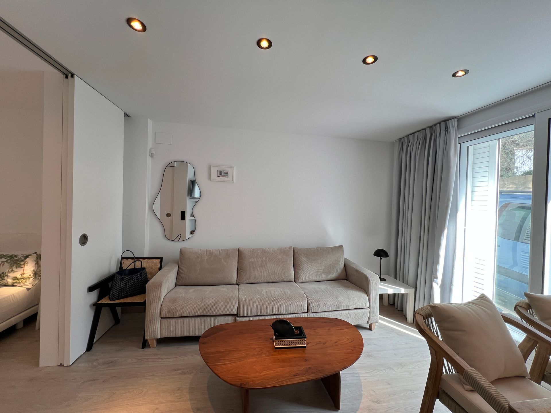 Living room with a beige sofa, wooden coffee table, and sliding glass door.