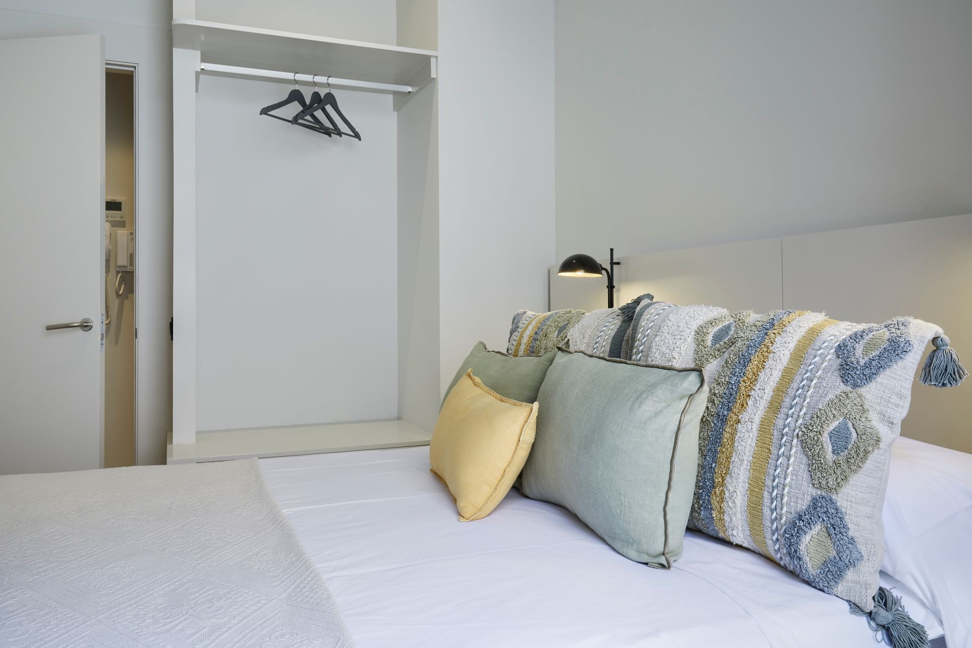A bed with a lot of pillows on it in a bedroom.