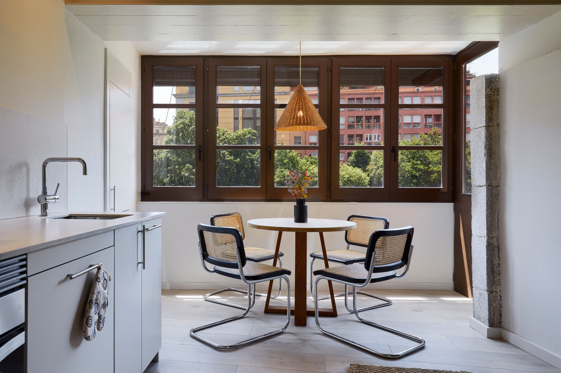 A kitchen with a table and chairs in front of a window.