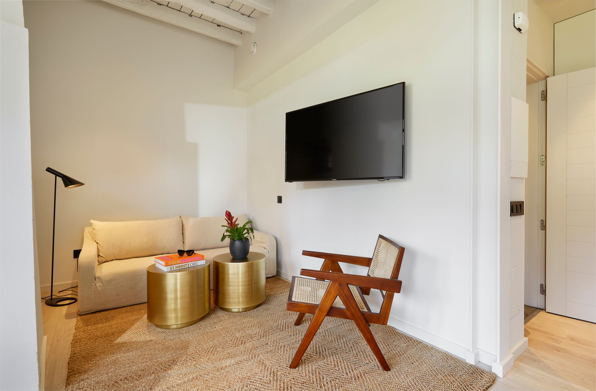 A living room with a couch , chair , table and television.
