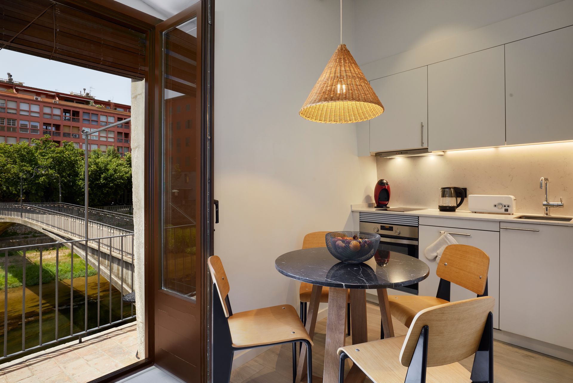 A kitchen with a table and chairs and a view of a bridge