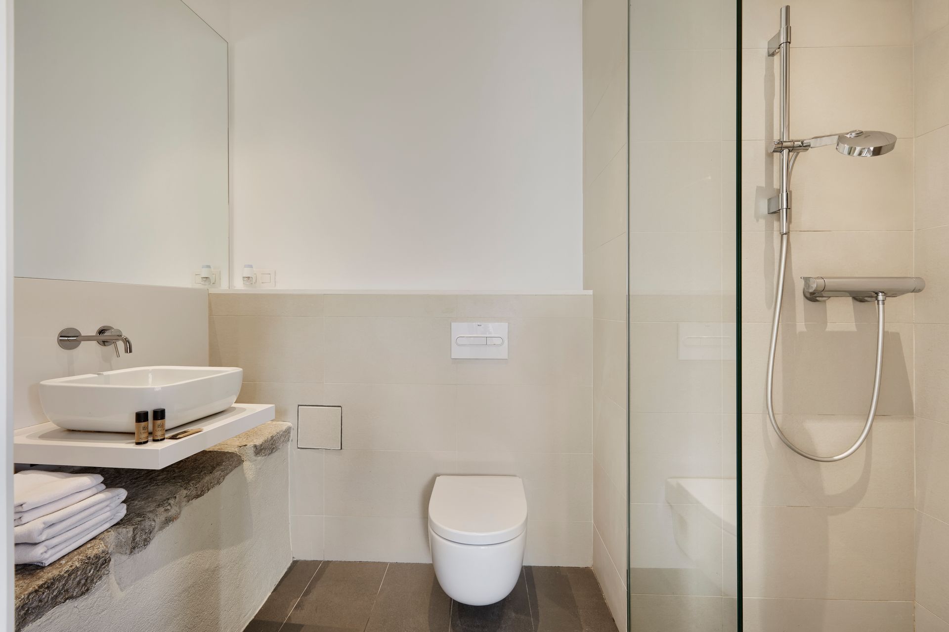 A bathroom with a toilet , sink and shower.