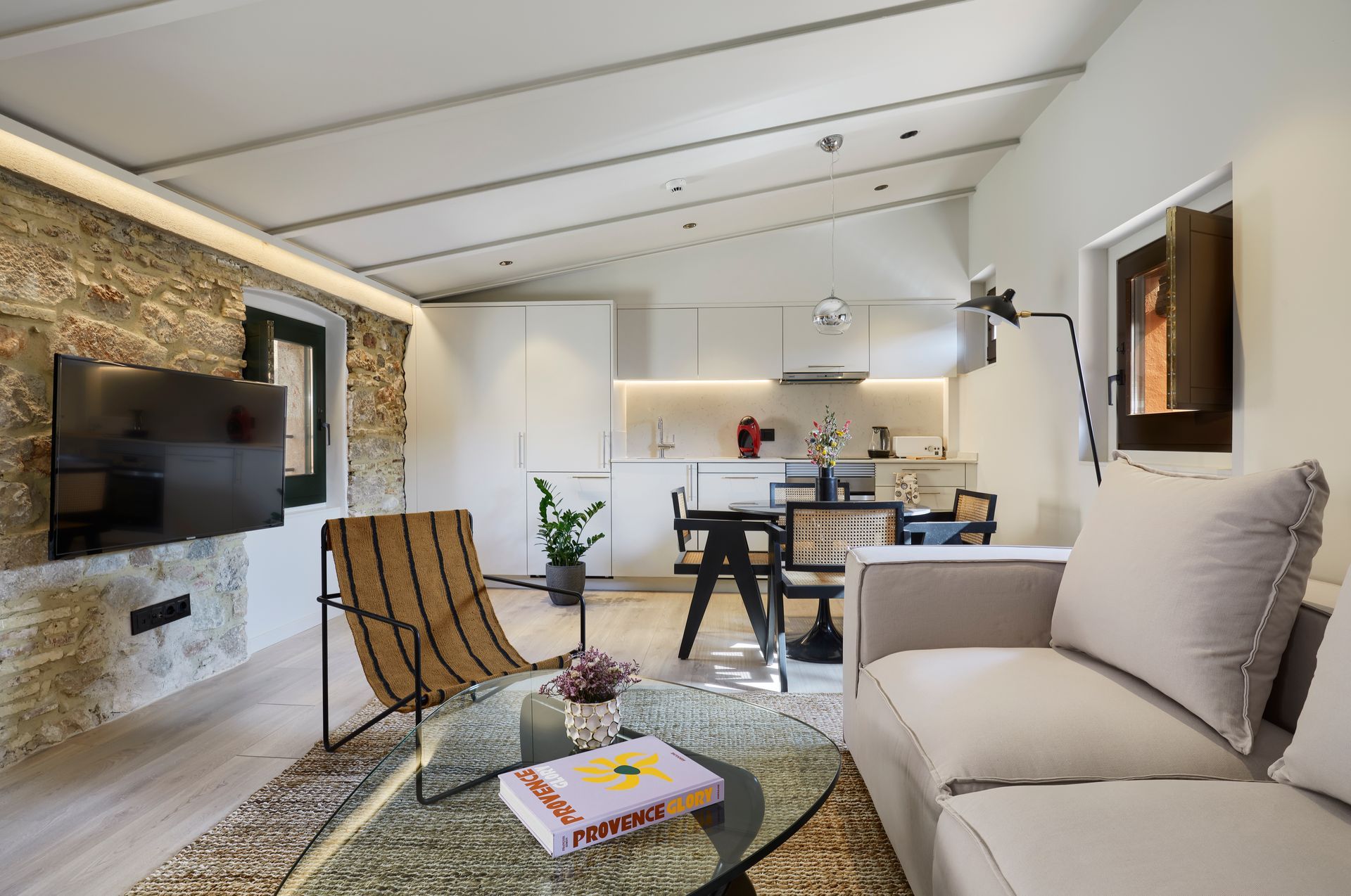 A living room with a couch , chair , table and television.