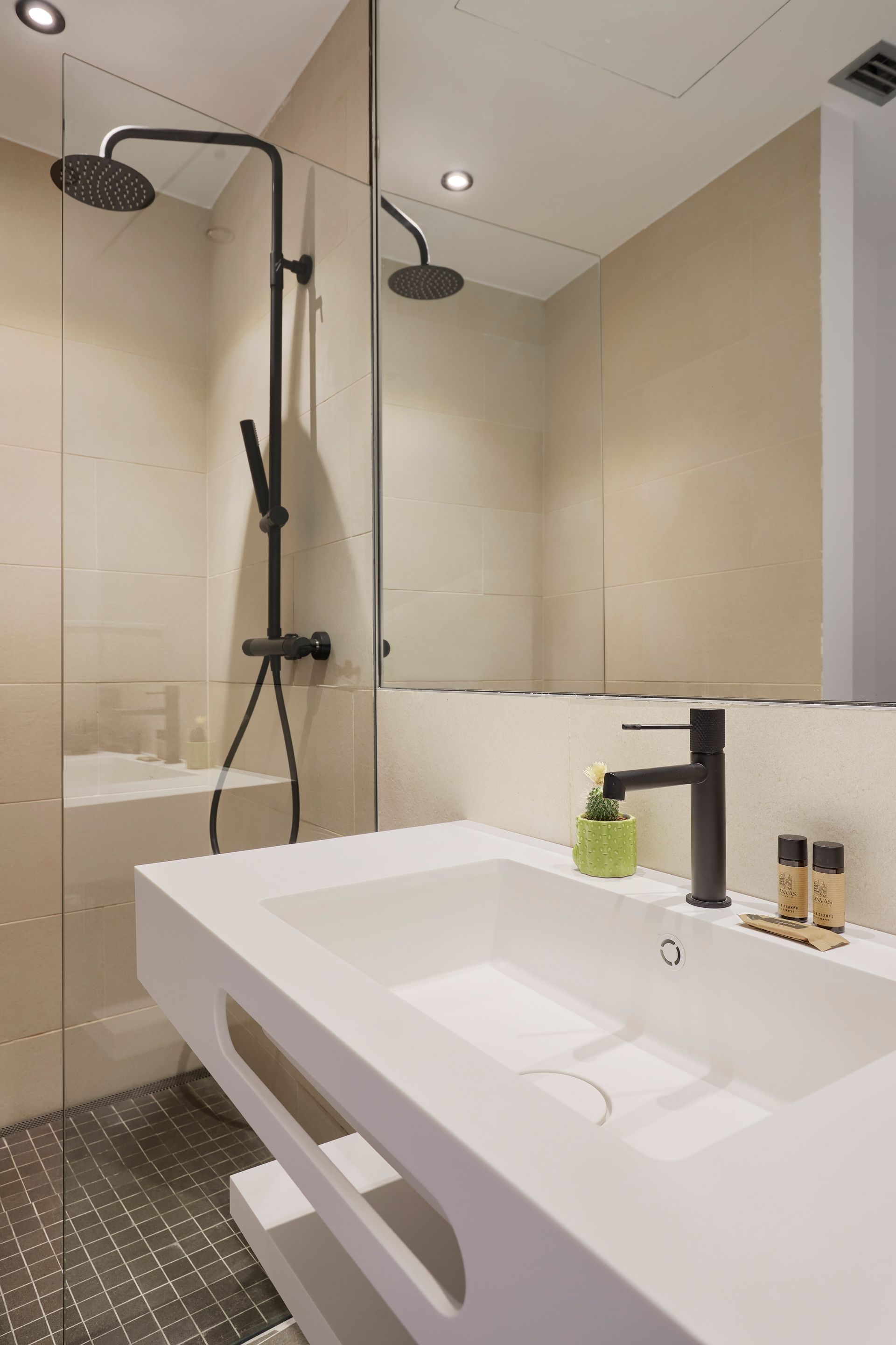 A bathroom with a sink , mirror and shower.
