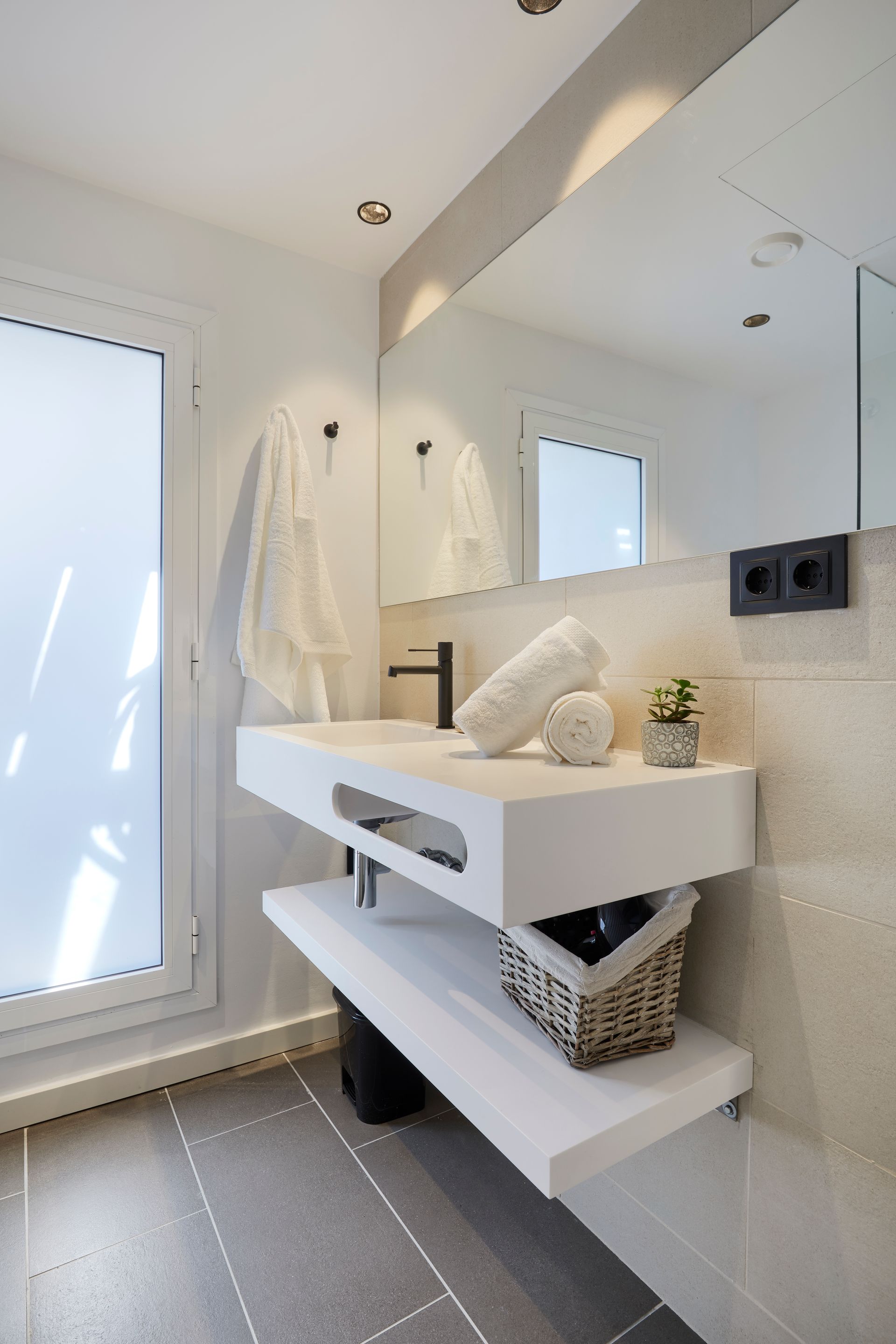 A bathroom with a sink and a large mirror
