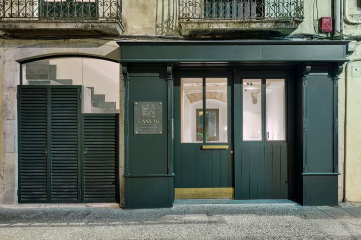 The front of a building with a green door and shutters