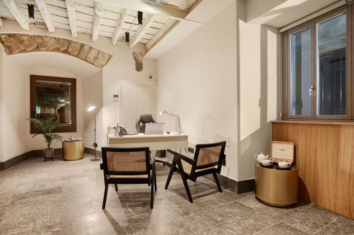 A room with two chairs , a desk and a window.