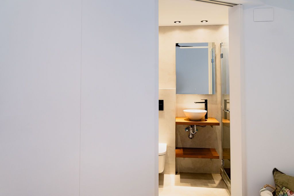 Bathroom with white walls and a view of a wood vanity, sink, and mirror.