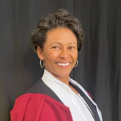 A woman in a green dress is smiling for the camera.