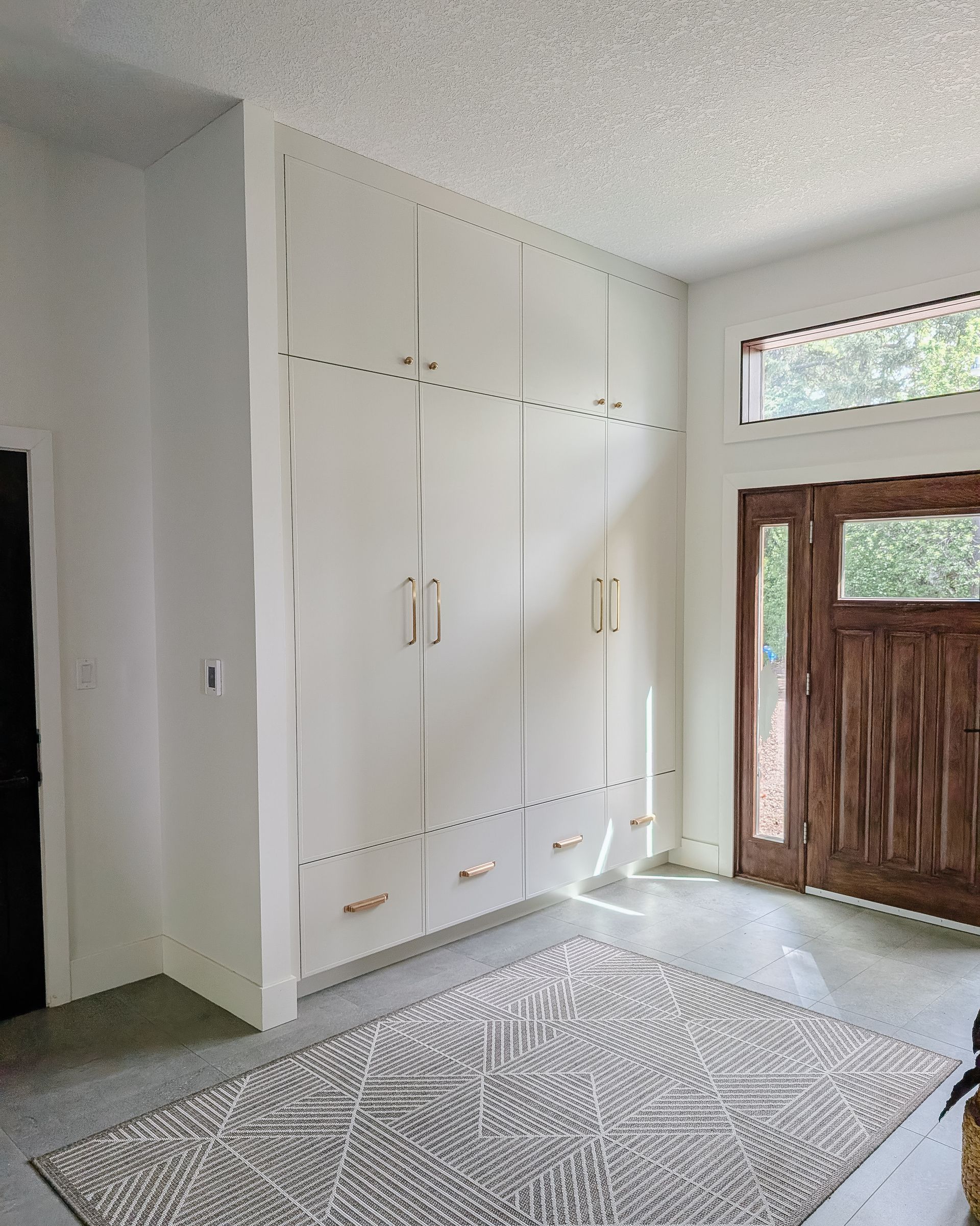 A modern kitchen with white cabinetry, hexagonal tile backsplash, stainless steel gas range, and various cooking utensils and