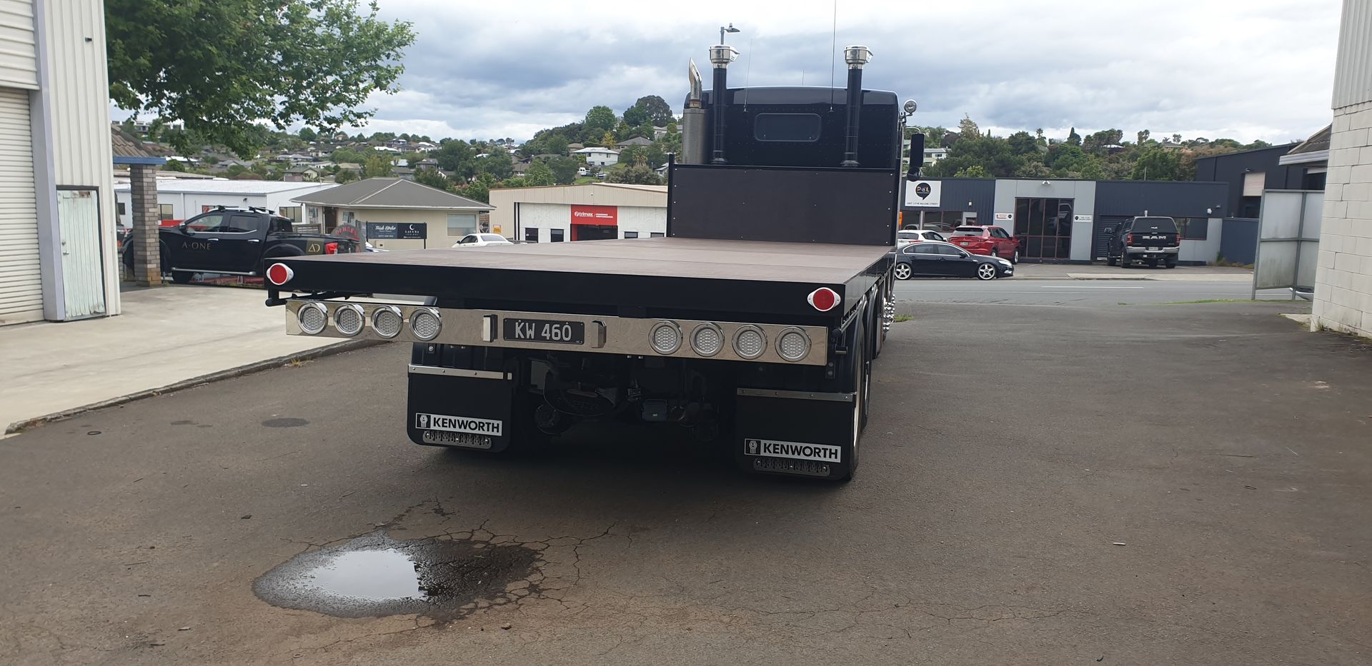 Black pickup truck with a flatbed cargo tray parked in a lot