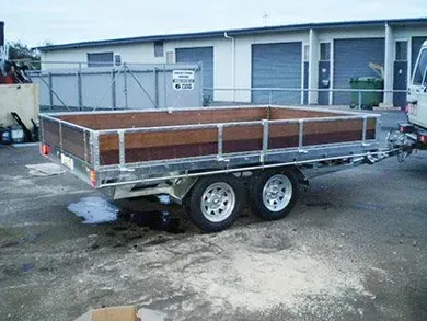 Blue flatbed truck with a metal cage cargo bed parked outdoors