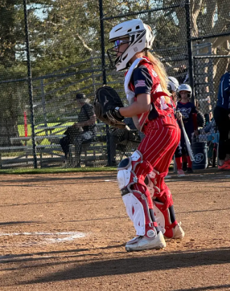 Softball catcher in red and white striped uniform 