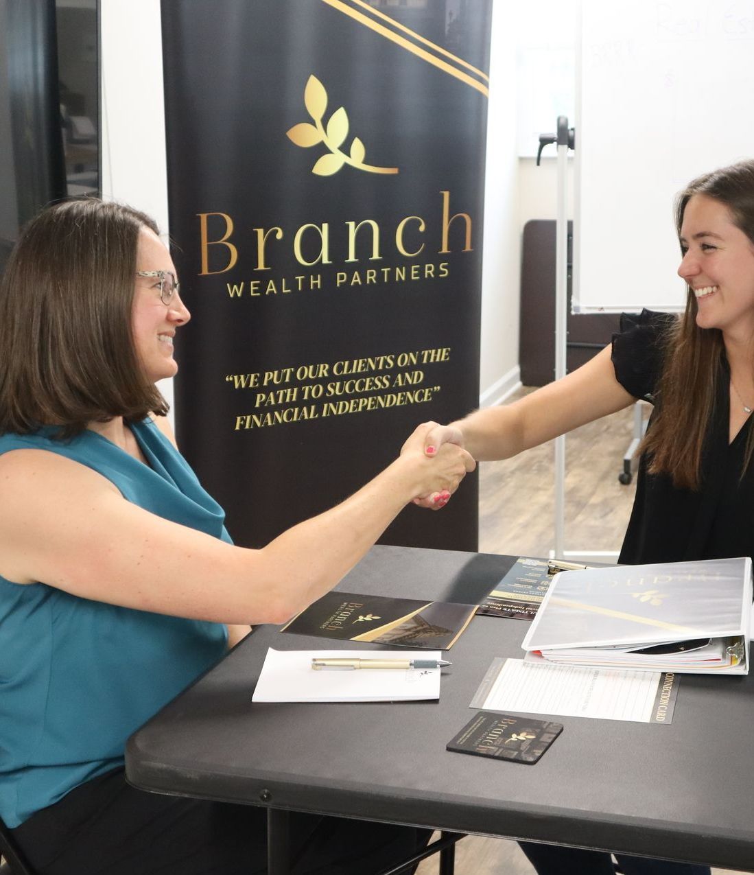 two women shaking hands at a real estate investing consulting appointment with Branch Wealth Partners