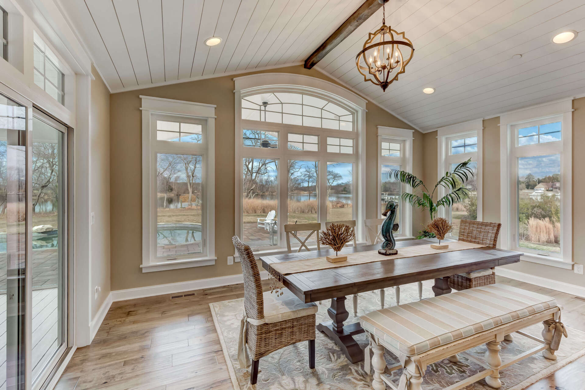 A dining room with a table and chairs and a bench.