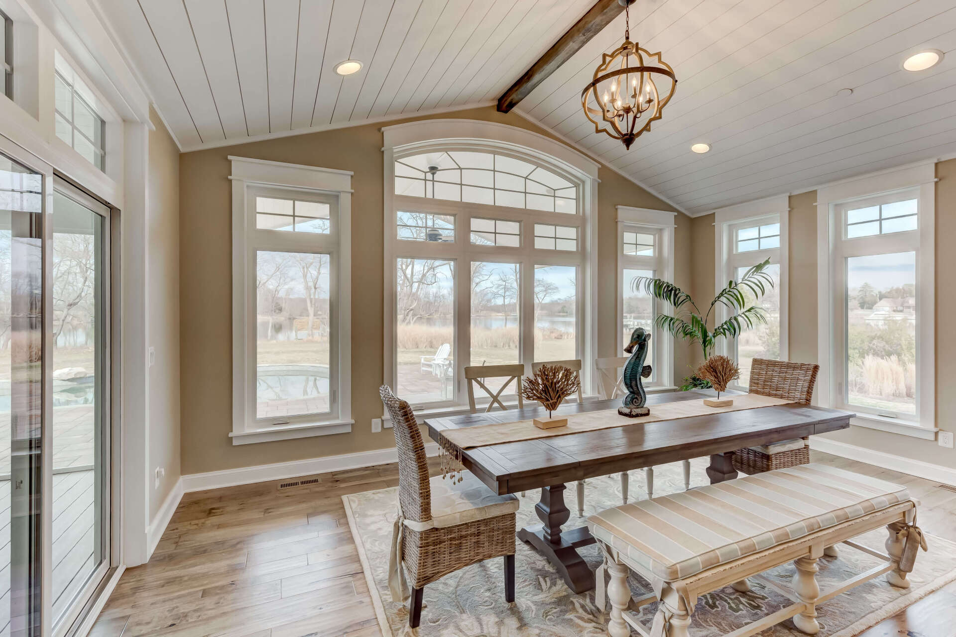 A dining room with a table and chairs and a bench.