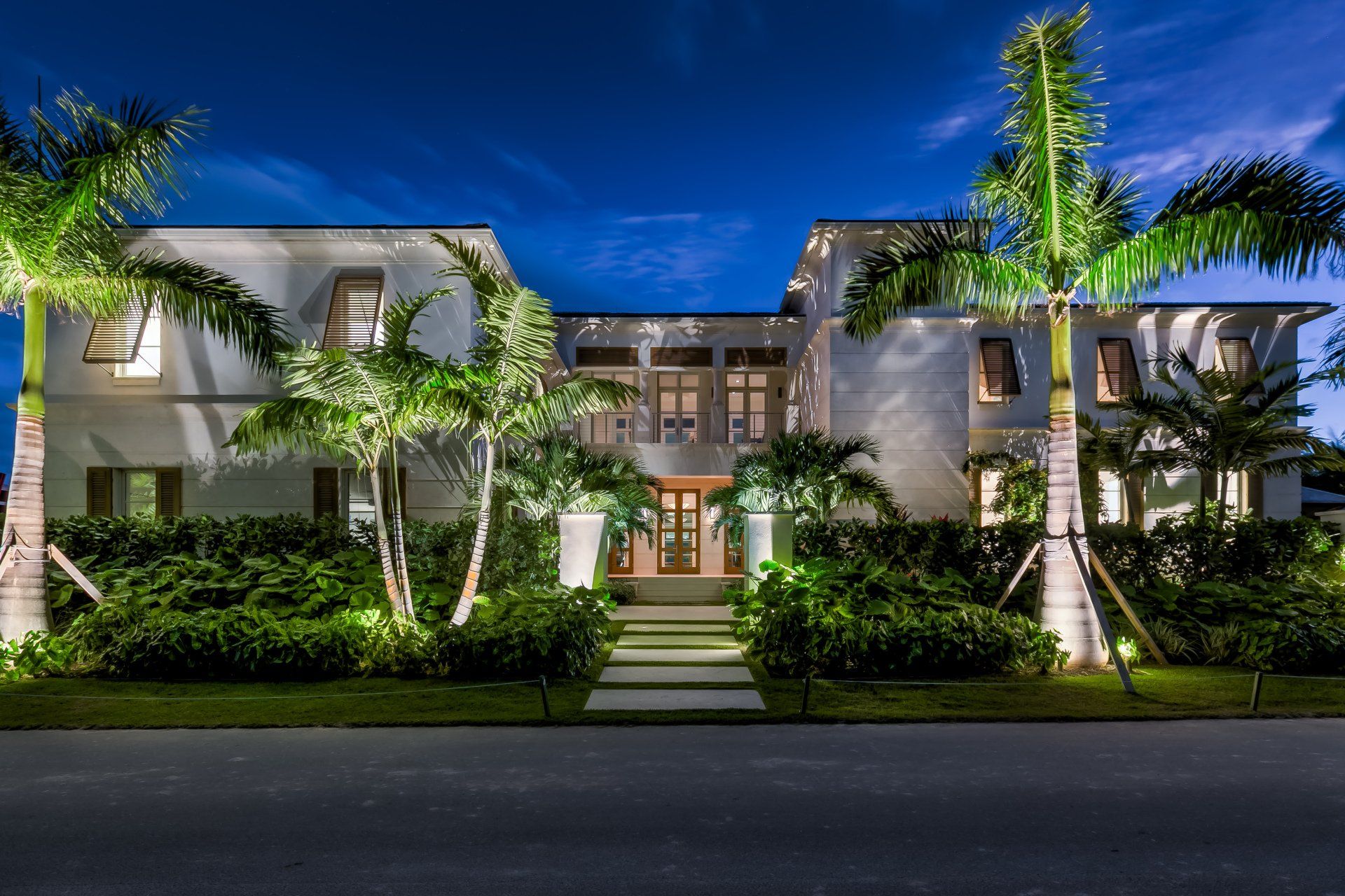 A large white house with palm trees in front of it at night - twilight shoot by Craig Westerman A large white house with palm trees in front of it at night - twilight shoot by Craig Westerman
