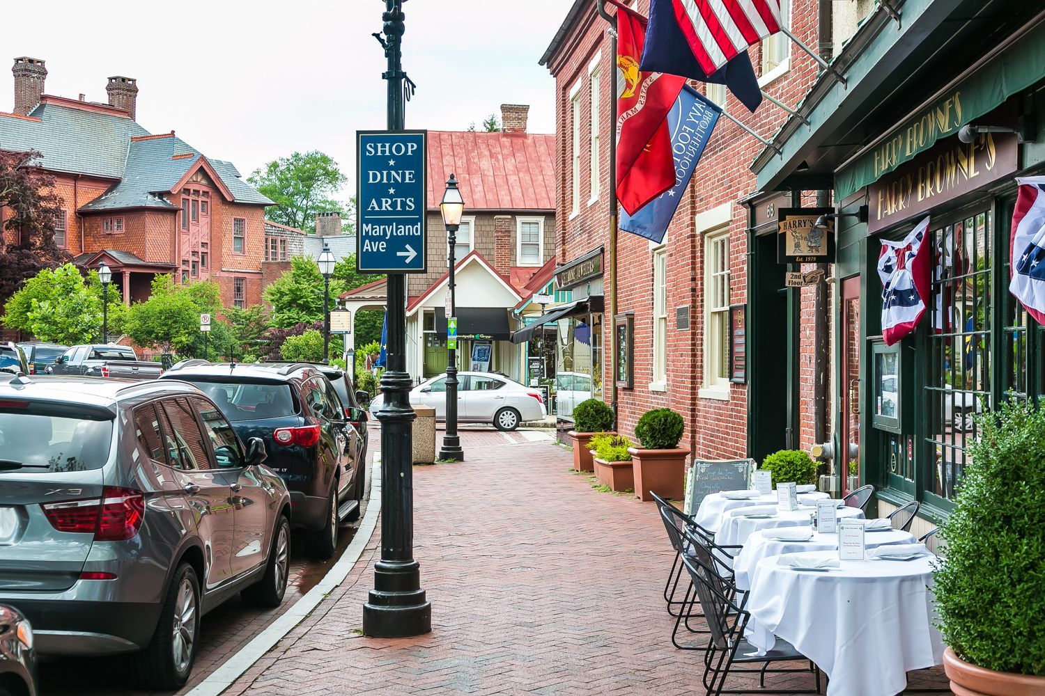 A brick sidewalk with tables and chairs in front of a restaurant near Maryland Avenue where shops, dine, and art reside. Photo shoot by Craig Westerman.