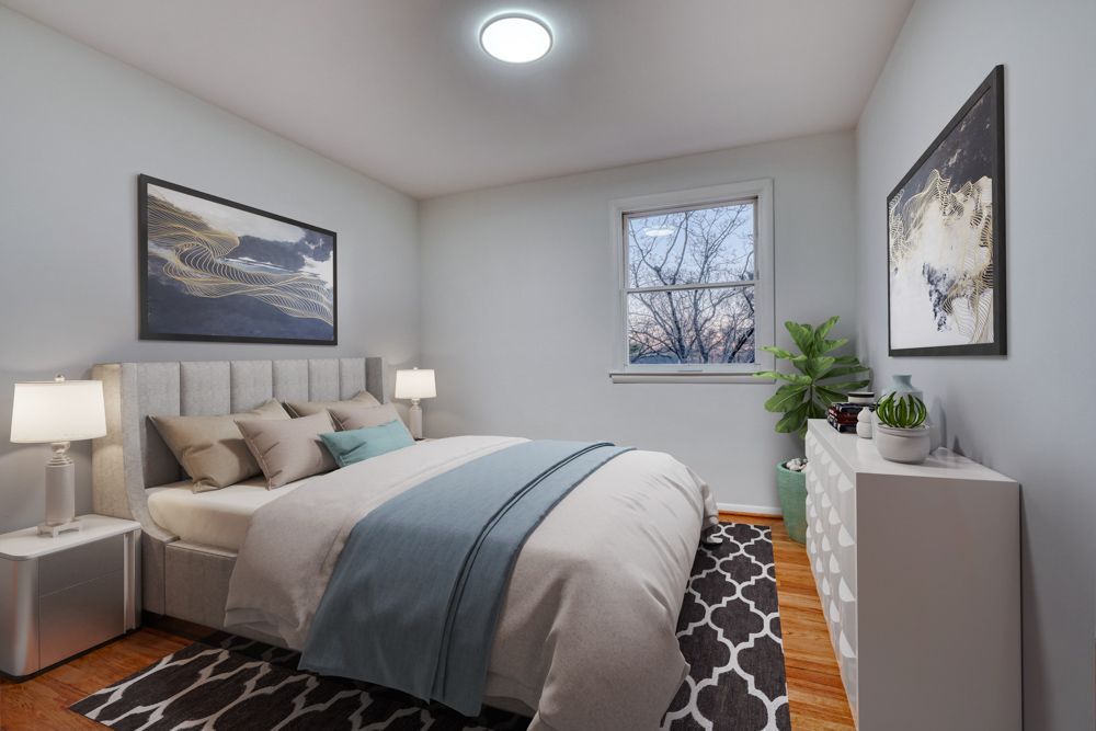 A bedroom with a bed , dresser , nightstands , and a window.