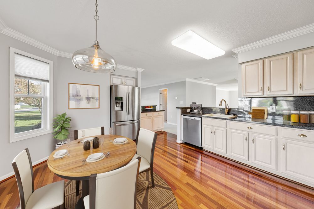 A kitchen with a table and chairs in it and a dining room.