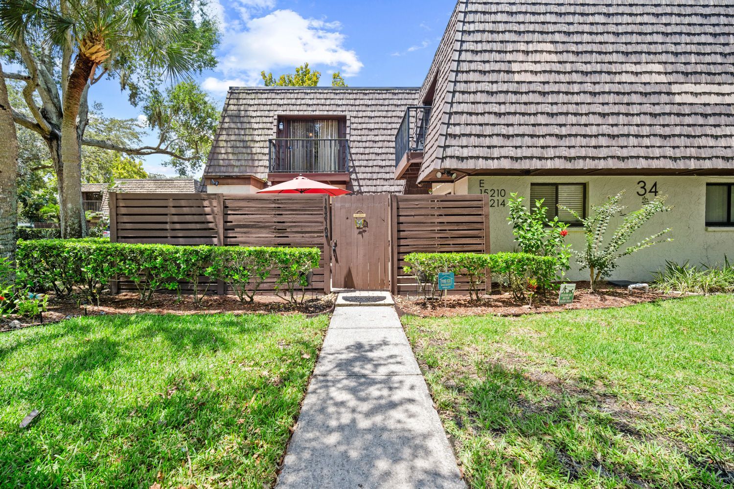 A house with a wooden fence and a walkway leading to in Tampa by Craig Westerman