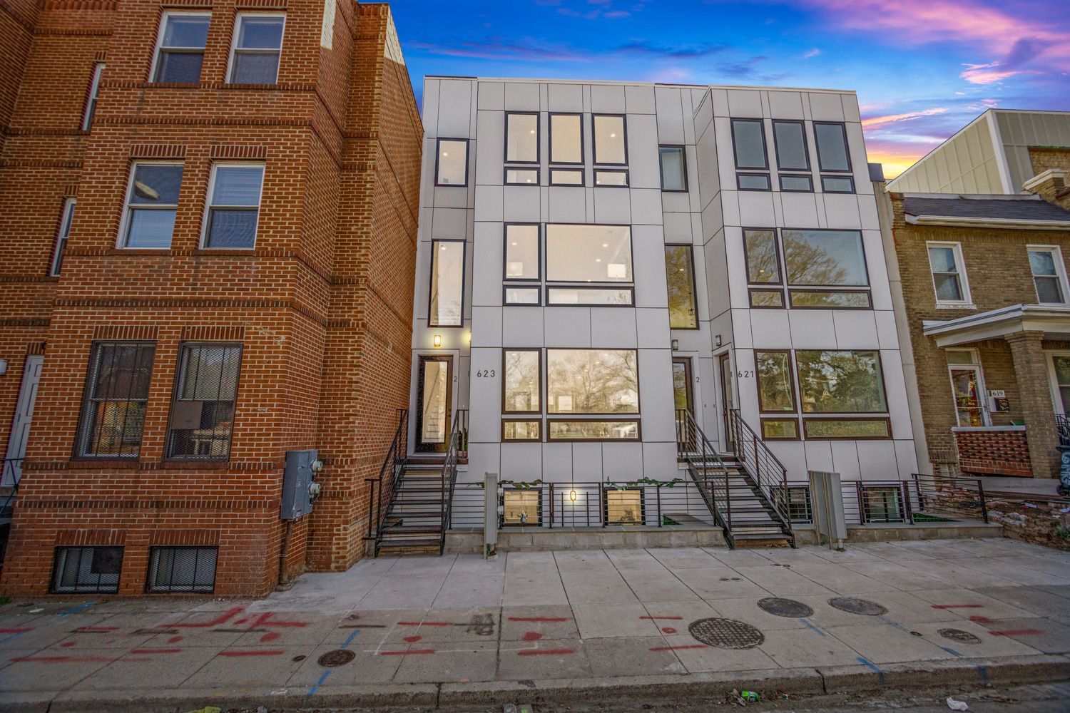 A brick building and a white building are next to each other on a city street.