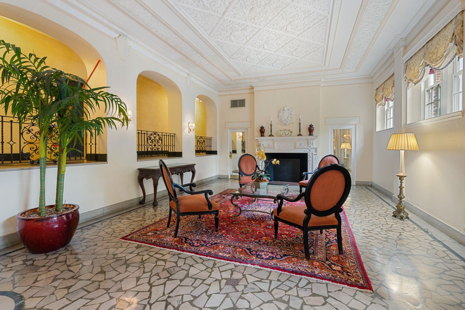 A living room with a fireplace , chairs , and a rug.