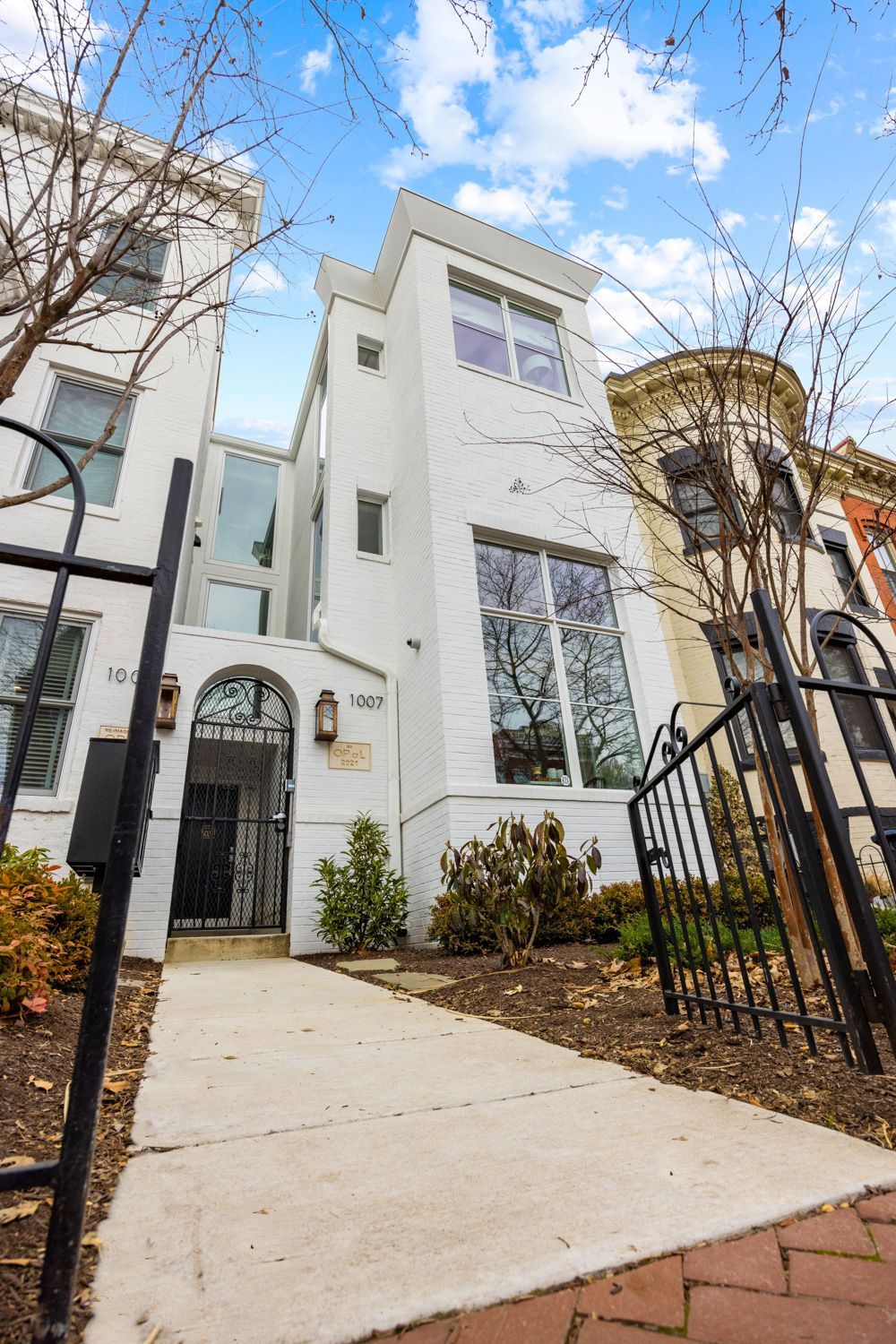 A white building with a fence and a walkway leading to it.